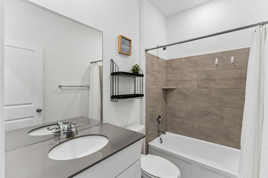 A well-appointed bathroom with contemporary fixtures and a tiled shower-tub combination.