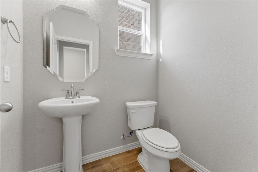 Bathroom featuring a textured wall and wood tiled floors