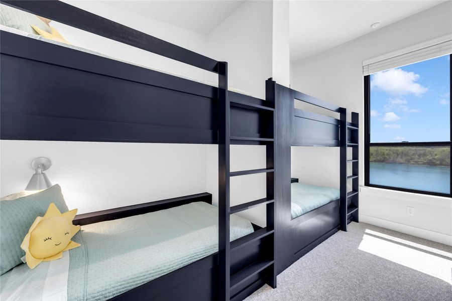 Bedroom eight: Sunlight streams through the large window, highlighting the crisp walls and custom built-in bunk beds.