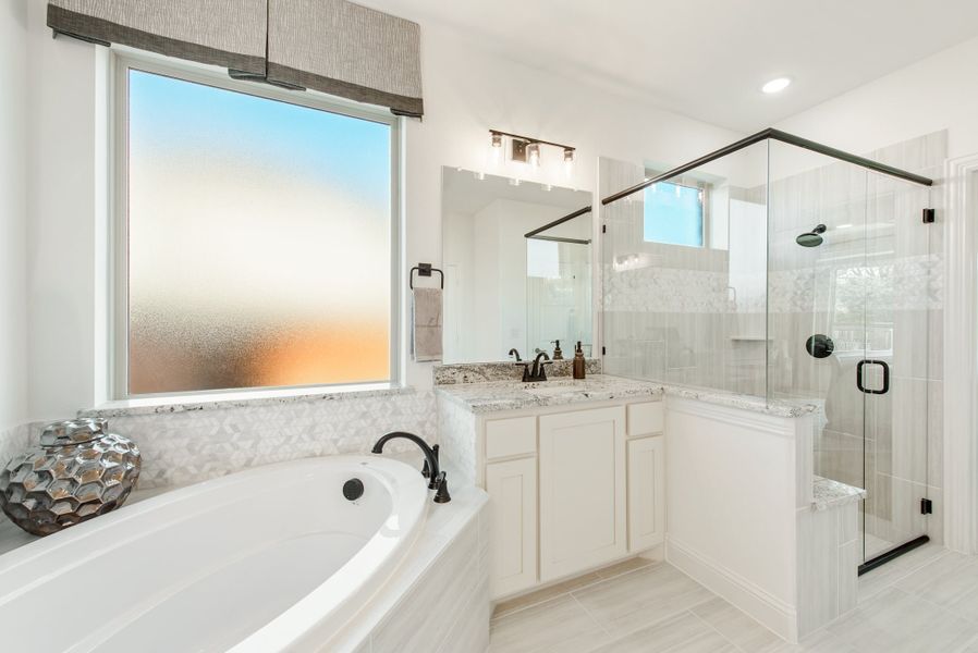 Master bathroom with soaking tub, glass walk-in shower, white vanity, and granite countertops Master bathroom with soaking tub, glass walk-in shower, white vanity, and granite countertops