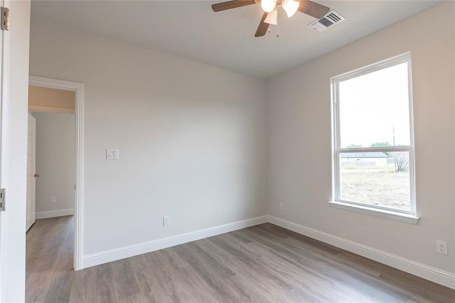 Unfurnished room featuring ceiling fan and light hardwood / wood-style flooring