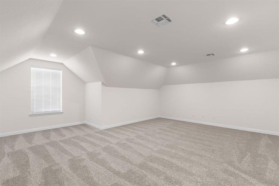 Additional living space featuring light carpet, vaulted ceiling, and recessed lighting Additional living space featuring light carpet, vaulted ceiling, and recessed lighting