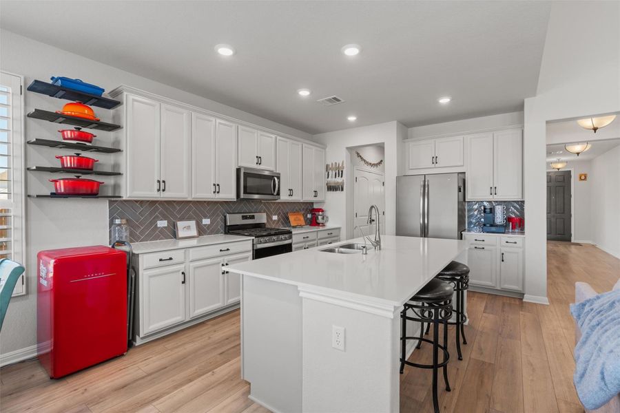 Which features silestone countertops, a large center island, a five burner gas cooktop, stinless steel appliances and touchless faucet for easy cooking and meal prep.