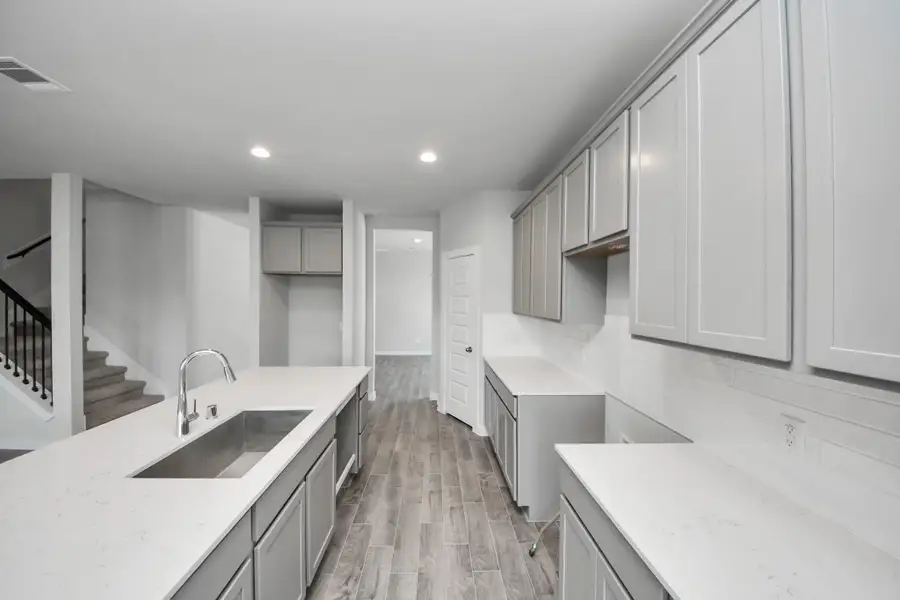 Discover another perspective of this stunning kitchen, generously appointed with an abundance of counter space. Sample photo of completed home with similar floor plan. Actual colors and selections may vary.