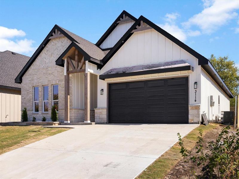 Modern inspired farmhouse featuring concrete driveway, board and batten siding, stone siding, an attached garage, and a shingled roof