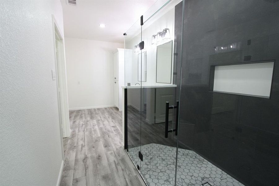 Bathroom featuring light wood finished floors, a stall shower, vanity, and recessed lighting Bathroom featuring light wood finished floors, a stall shower, vanity, and recessed lighting