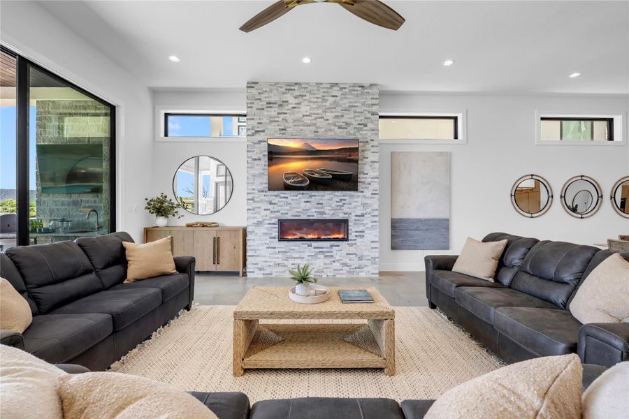 An impressive floor-to-ceiling stone fireplace serves as the centerpiece of this modern living area.