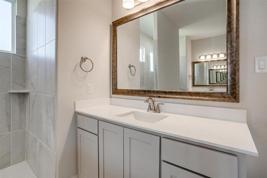 Bathroom with a tile shower and vanity