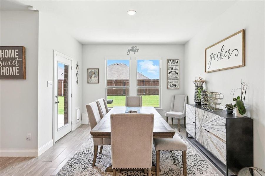 Dining area with light wood-style flooring and baseboards