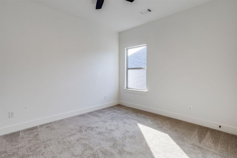 Unfurnished room featuring light carpet and a ceiling fan