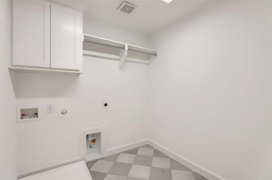 Clothes washing area featuring hookup for an electric dryer, hookup for a washing machine, gas dryer hookup, and cabinets