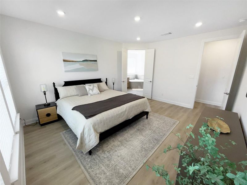 Bedroom featuring light wood-type flooring, recessed lighting, and ensuite bath