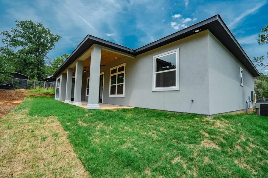Modern home with a covered patio for outdoor enjoyment, overlooking a green lawn. Modern home with a covered patio for outdoor enjoyment, overlooking a green lawn.