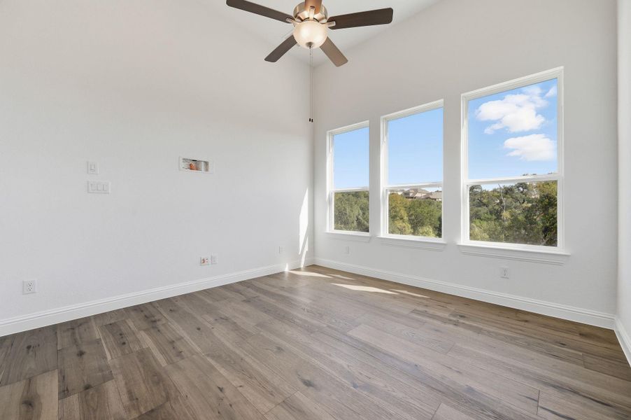 Empty room featuring wood finished floors and a ceiling fan
