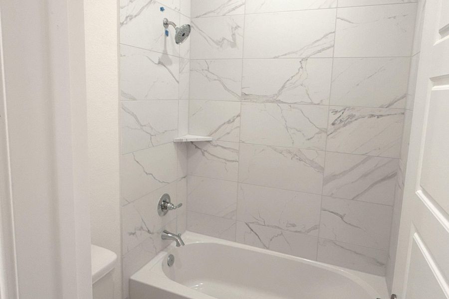 Bathroom featuring toilet and washtub / shower combination