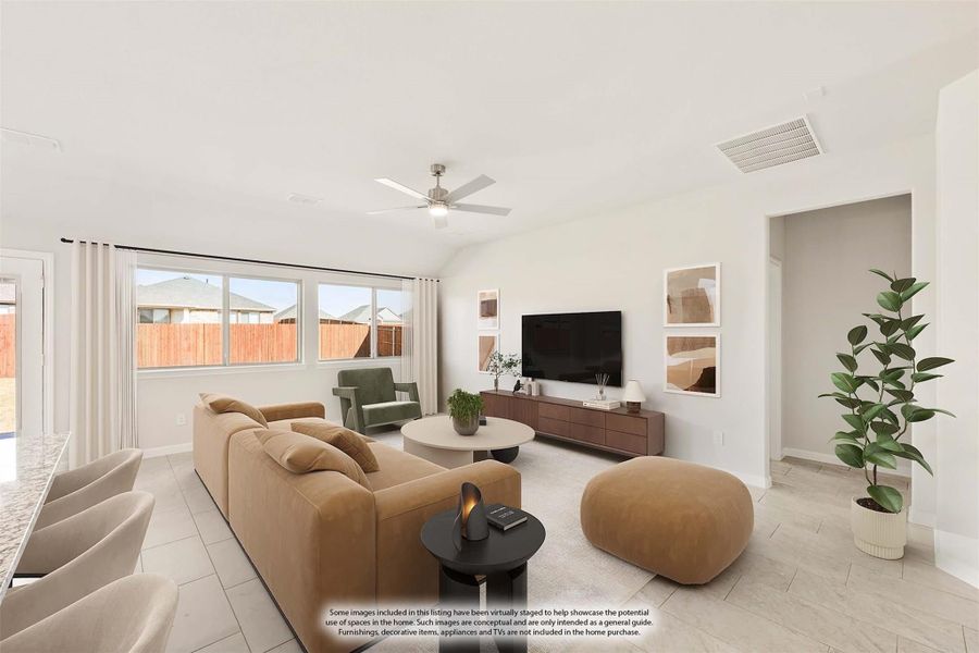 Living room with vaulted ceiling, ceiling fan, tan sectional sofa, and wall-mounted TV on wood media console