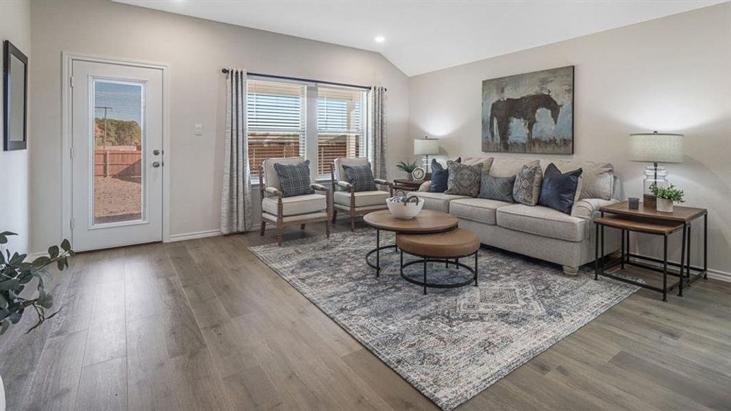 Living area with wood finished floors, lofted ceiling, and recessed lighting