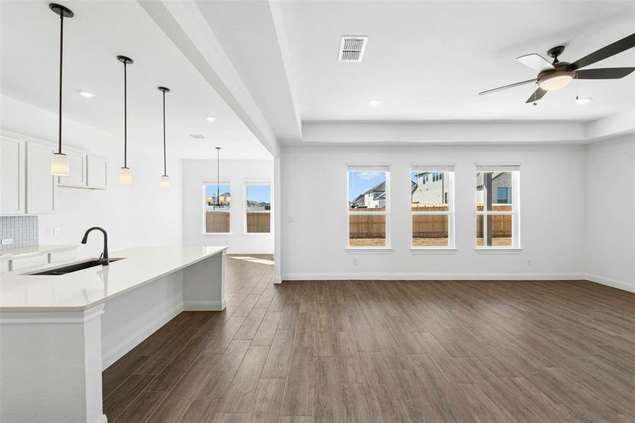 Open-concept interior featuring wood-look tile flooring throughout, recessed lighting, and a contemporary ceiling fan