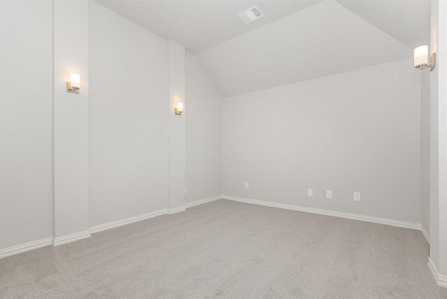 Additional living space with light colored carpet and lofted ceiling
