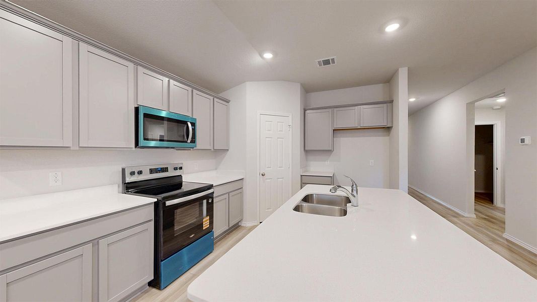 A well-appointed kitchen features ample counter space, contemporary cabinetry, and modern appliances.