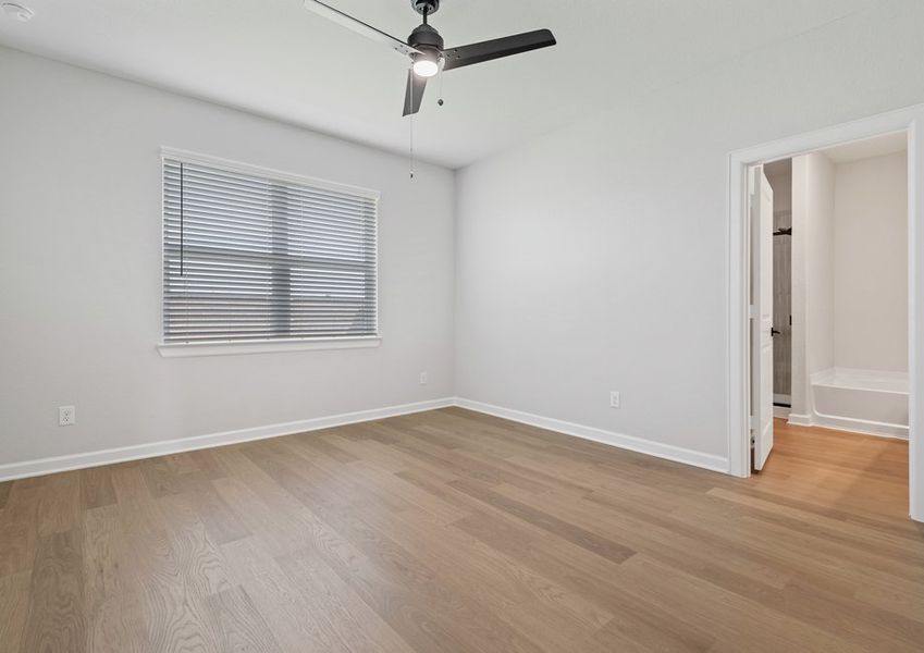 Master bedroom with a large window and ceiling fan light fixture