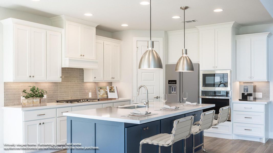 Kitchen with a sink, stainless steel appliances, light countertops, a breakfast bar area, and white cabinetry Kitchen with a sink, stainless steel appliances, light countertops, a breakfast bar area, and white cabinetry