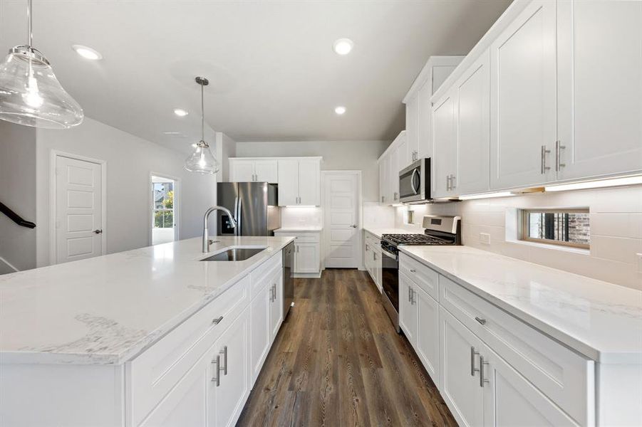 A beautiful crisp clean white color palette and striking dark flooring effortlessly pair with contemporary stainless steel to create a kitchen for the ages!