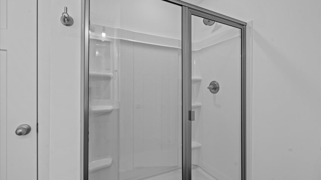 Memorable mornings begin in this elegant primary bathroom with walk-in shower and double vanity
