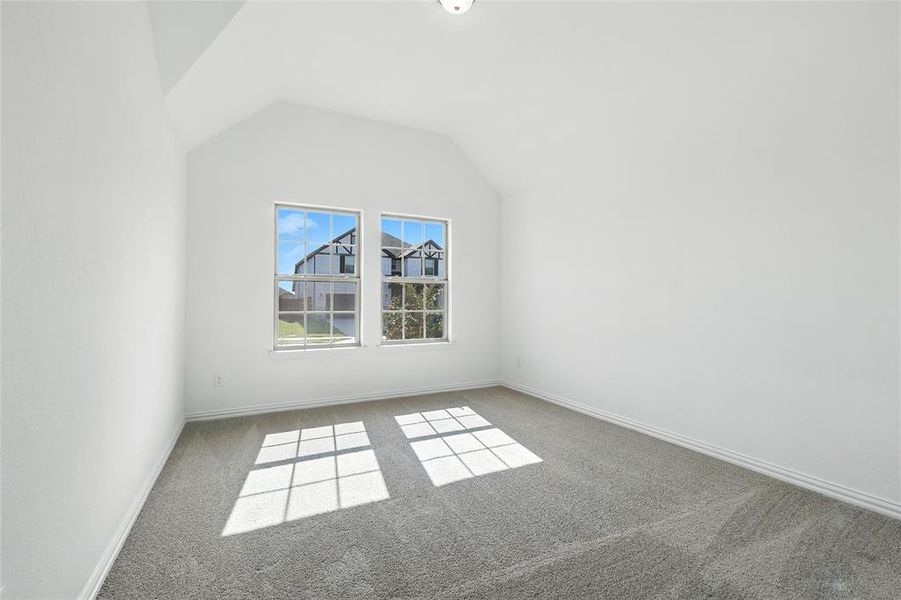 Bonus room with light colored carpet and baseboards