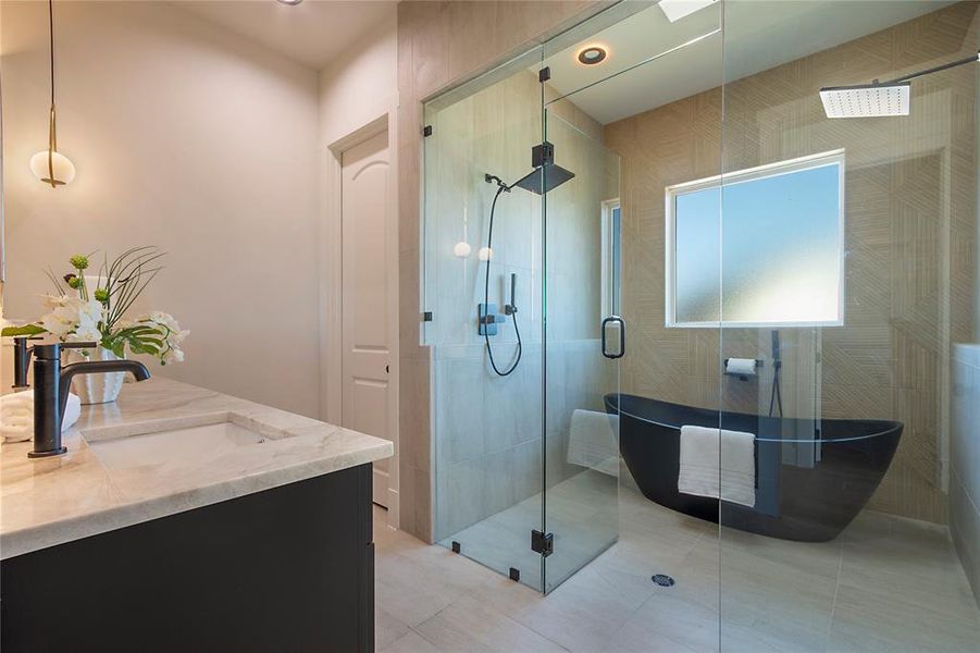 Bathroom with double vanity, a stall shower, a freestanding tub, and light tile patterned floors Bathroom with double vanity, a stall shower, a freestanding tub, and light tile patterned floors