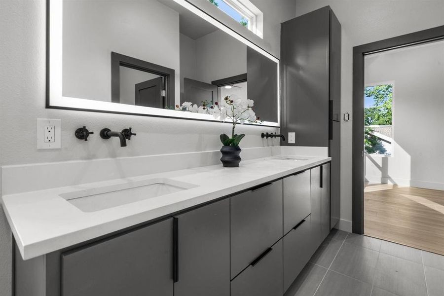 Bathroom with plenty of natural light, double vanity, and light tile patterned flooring
