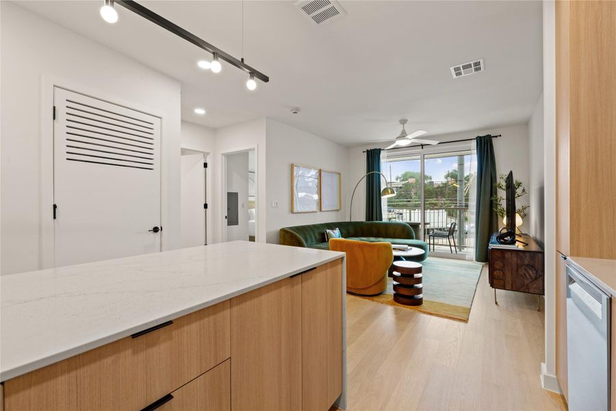 A light-filled open layout connects the modern kitchen area to a glass-doored living space. A light-filled open layout connects the modern kitchen area to a glass-doored living space.