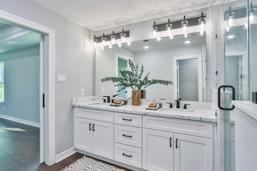 Elegance With A Zen Ambience in the primary bathroom with double sinks and stylish fixtures and faucets.