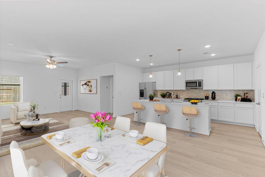 The gourmet kitchen overlooks the family room and dining area, featuring white cabinets, quartz countertops, and a large island with bar seating—perfect for cooking, entertaining, or just enjoying time together.  Open the door an see the wonderful, covered patio to relax on!