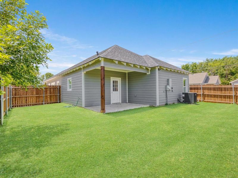 Back of house featuring a shingled roof, central AC, and a patio