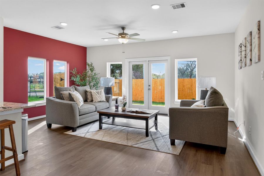 Bright and inviting living area filled with natural light, featuring expansive windows and French doors that seamlessly connect to the backyard. Bright and inviting living area filled with natural light, featuring expansive windows and French doors that seamlessly connect to the backyard.