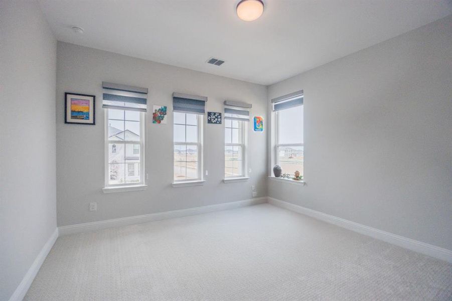 Unfurnished room with carpet, visible vents, and baseboards