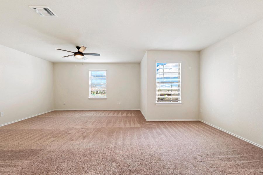 A spacious room offers comfortable carpet flooring and ample natural light through well-placed windows. A spacious room offers comfortable carpet flooring and ample natural light through well-placed windows.