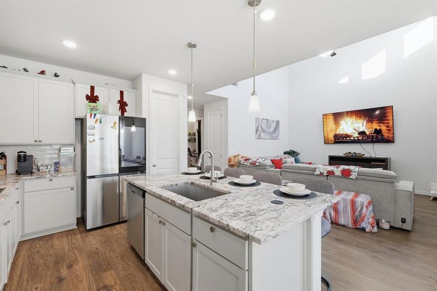 Kitchen with open floor plan, stainless steel appliances, and white cabinetry