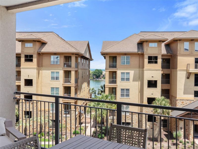 Balcony with metal railing overlooking a courtyard and lake Balcony with metal railing overlooking a courtyard and lake
