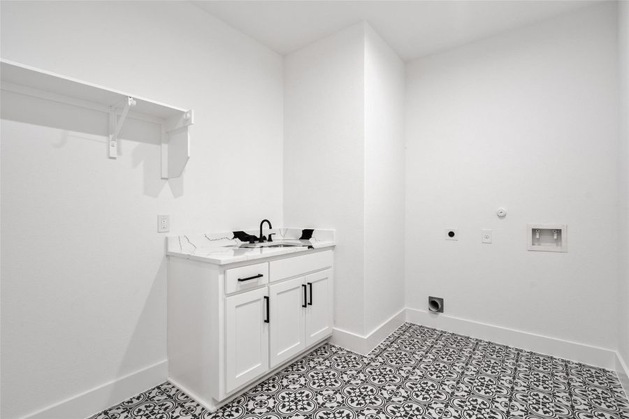 Laundry area with hookup for an electric dryer, hookup for a washing machine, hookup for a gas dryer, and cabinet space