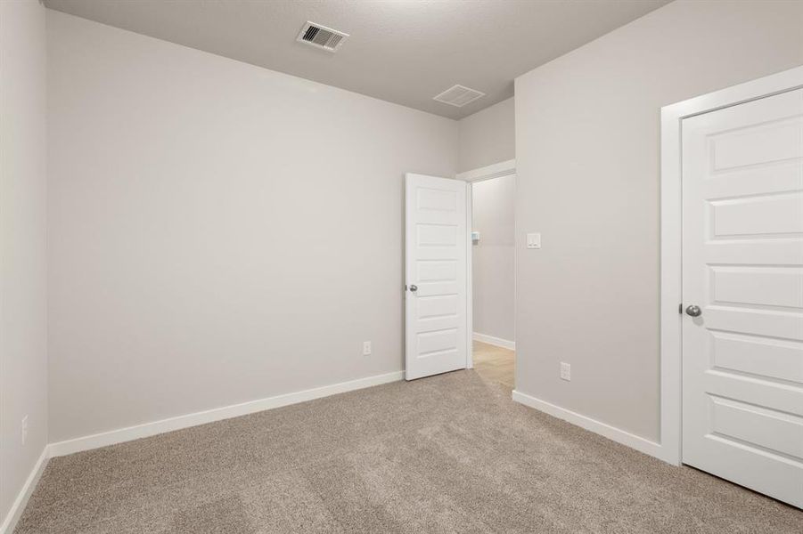 Striking Secondary bedroom featuring plush carpet, neutral finishes and easy access to the Flex Space and bathroom.