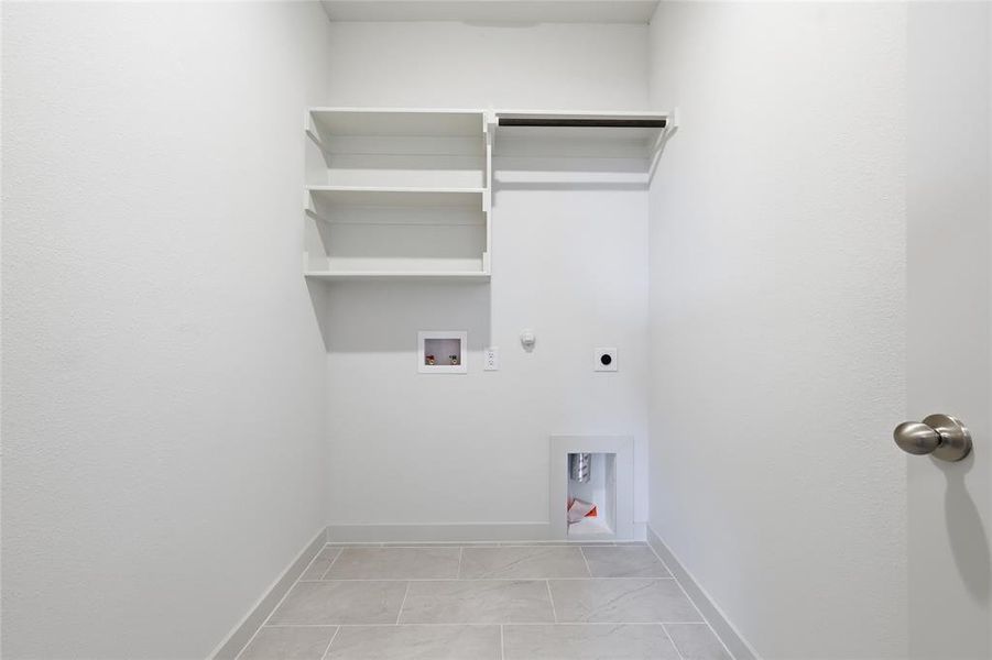 Laundry area featuring gas dryer hookup, hookup for a washing machine, and electric dryer hookup Laundry area featuring gas dryer hookup, hookup for a washing machine, and electric dryer hookup