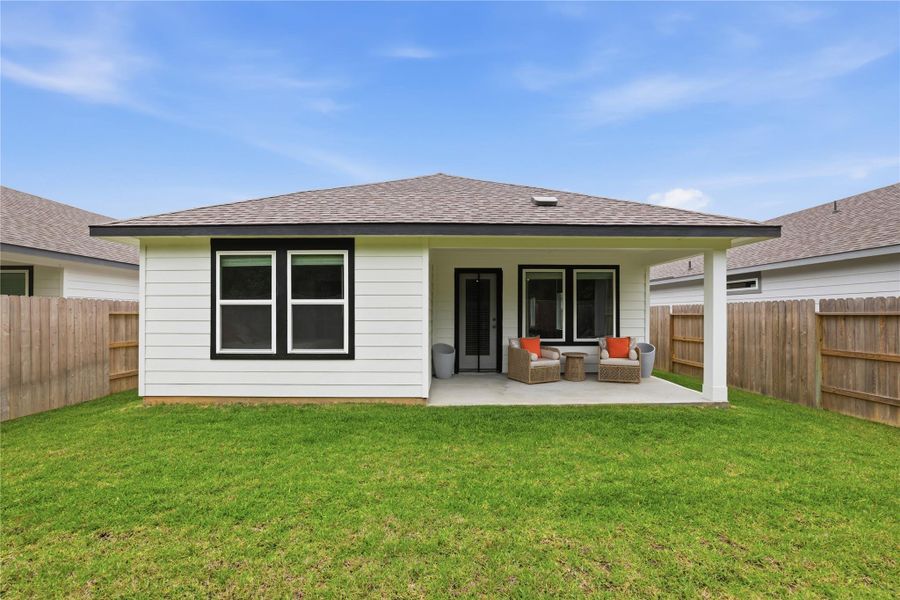 Charming backyard with a covered patio, perfect for relaxing. The fenced yard offers privacy, with a well-maintained lawn and cozy outdoor seating area. Ideal for outdoor gatherings and leisure.