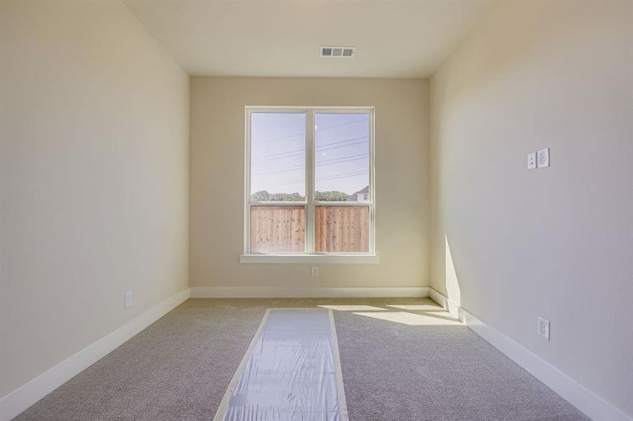 Carpeted empty room featuring baseboards