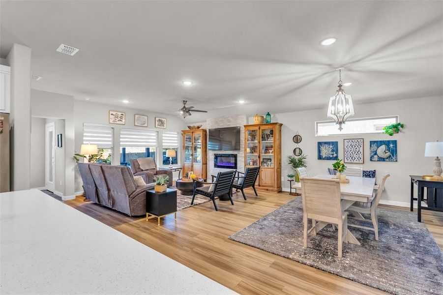 Dining area featuring plenty of natural light, ceiling fan with notable chandelier, and light wood-type flooring