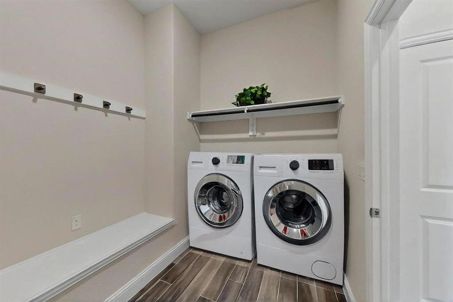 Laundry room with wood finish floors and washer and clothes dryer