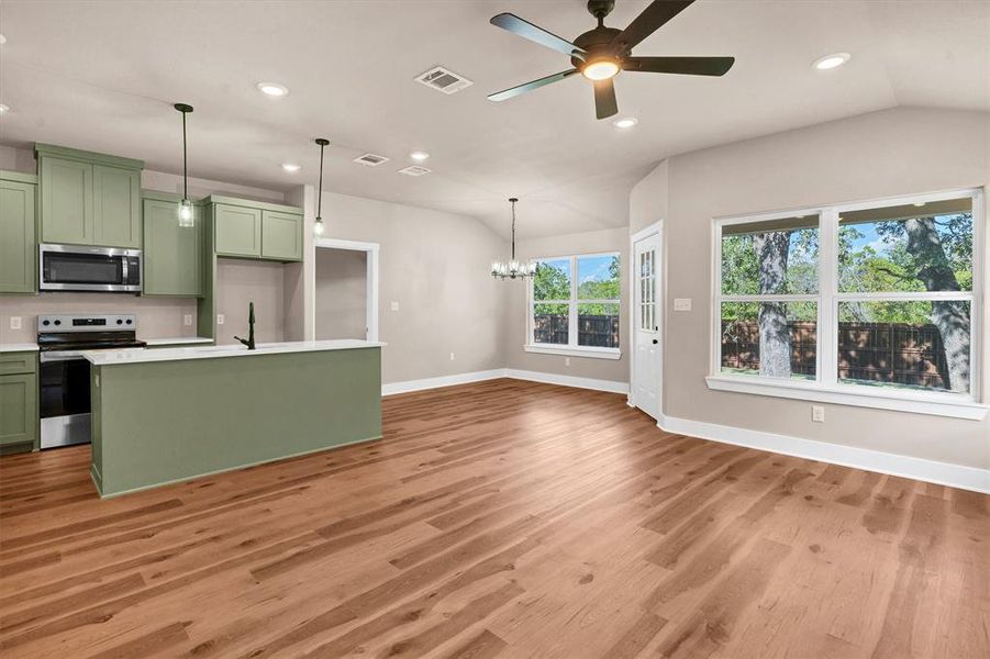 Kitchen featuring green cabinetry, stainless steel appliances, recessed lighting, a chandelier, and decorative light fixtures Kitchen featuring green cabinetry, stainless steel appliances, recessed lighting, a chandelier, and decorative light fixtures