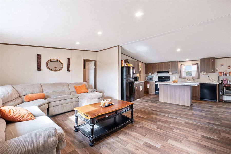 Living area with ornamental molding, light wood-style floors, and recessed lighting