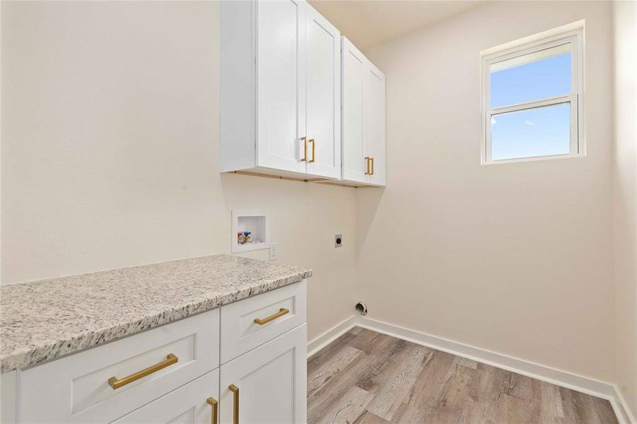 Laundry area with cabinet space, light wood finished floors, washer hookup, and hookup for an electric dryer Laundry area with cabinet space, light wood finished floors, washer hookup, and hookup for an electric dryer